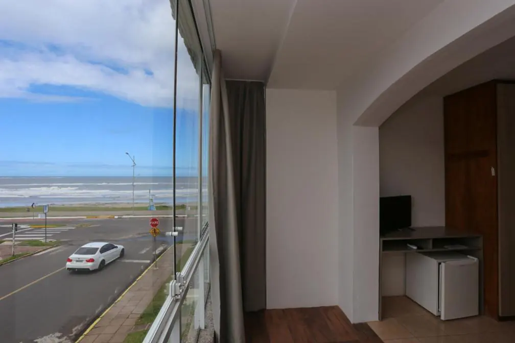 Janela de quarto da pousada com vista do mar na Prainha, Torres